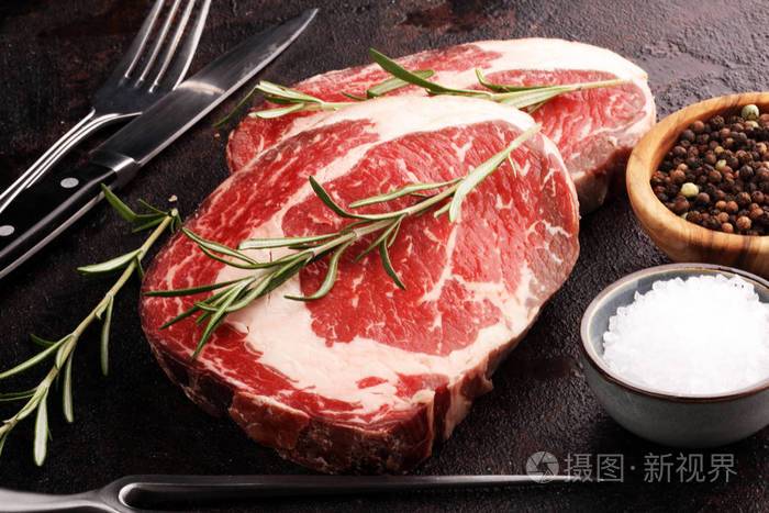 生鲜肉里脊牛排,调味料和肉叉子放在乡村b照片-正版商用图片26vf67-摄